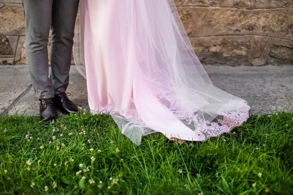 a bride and groom standing in front of a stone wall