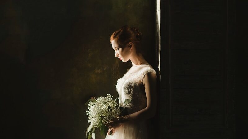 woman wearing wedding gown white holding bouquet