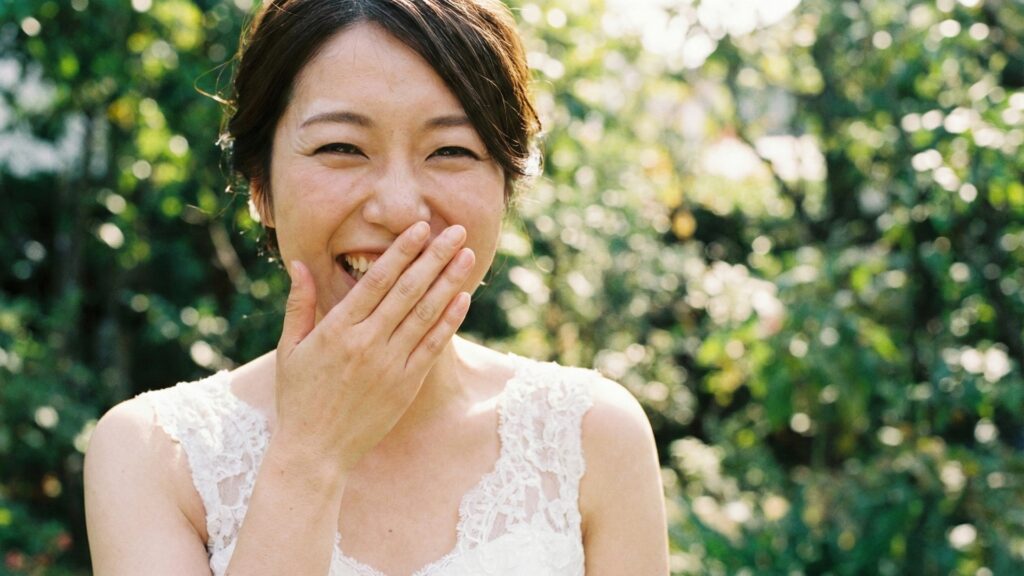 フォトウェディングの撮影中に緊張がほぐれ自然な笑顔を見せる瞬間の日本人花嫁
