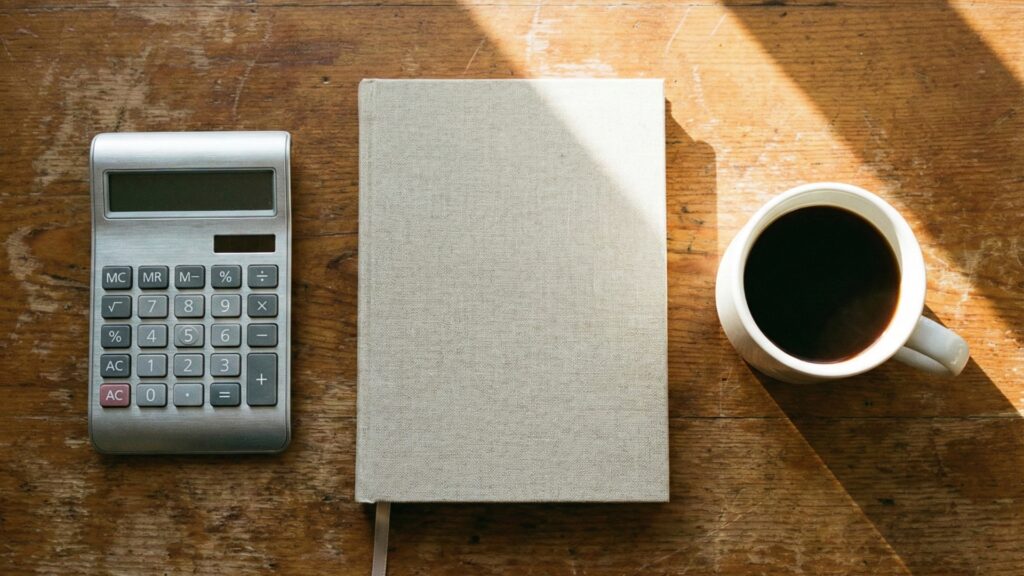 木の机に置かれた電卓とウェディングノート